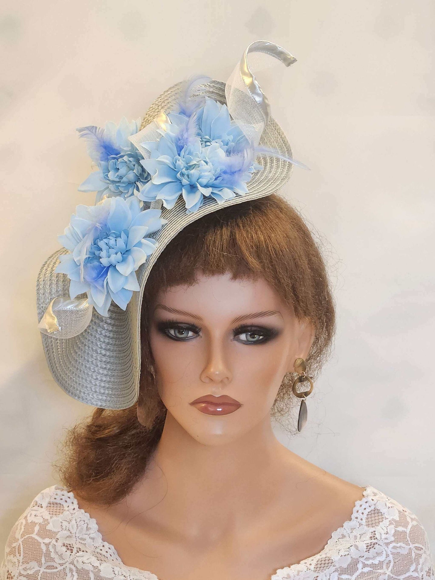 Silver and blue fascinator with feathers and flowers, ideal for weddings and special occasions.