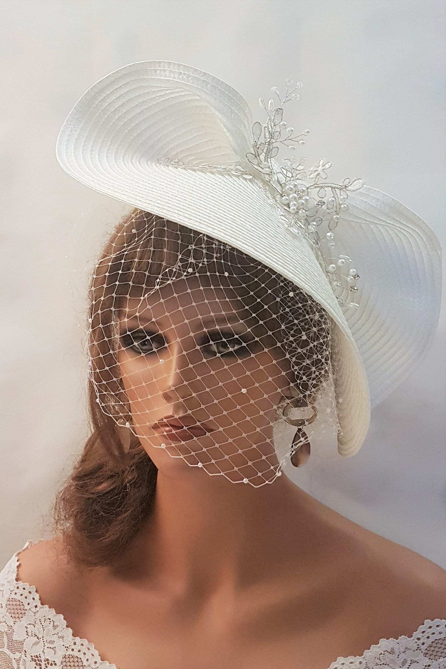 FASCINATOR with veil White Modern Bridal wedding headdress with Birdcage Veil. Adorned with stunning Silver thread Motif and with gently floating Pearls and crystals