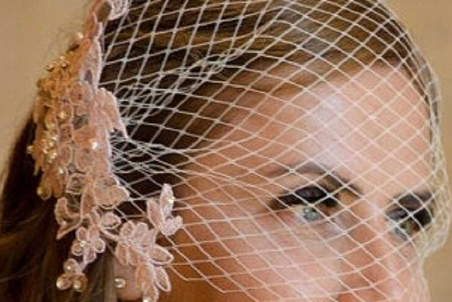 Blush pink birdcage veil with lace and pearl details, vintage-inspired bridal fascinator.
