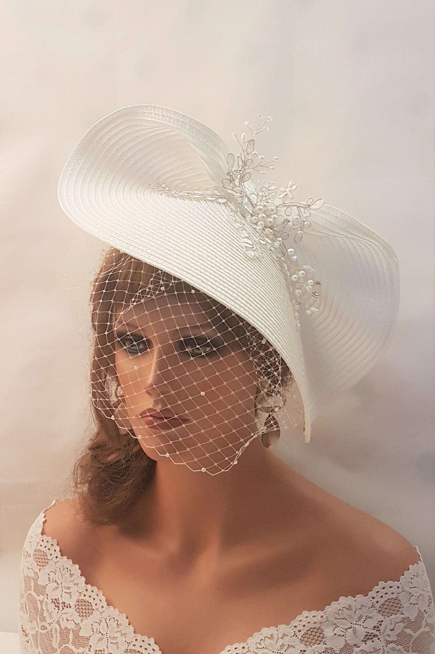 FASCINATOR with veil White Modern Bridal wedding headdress with Birdcage Veil. Adorned with stunning Silver thread Motif and with gently floating Pearls and crystals