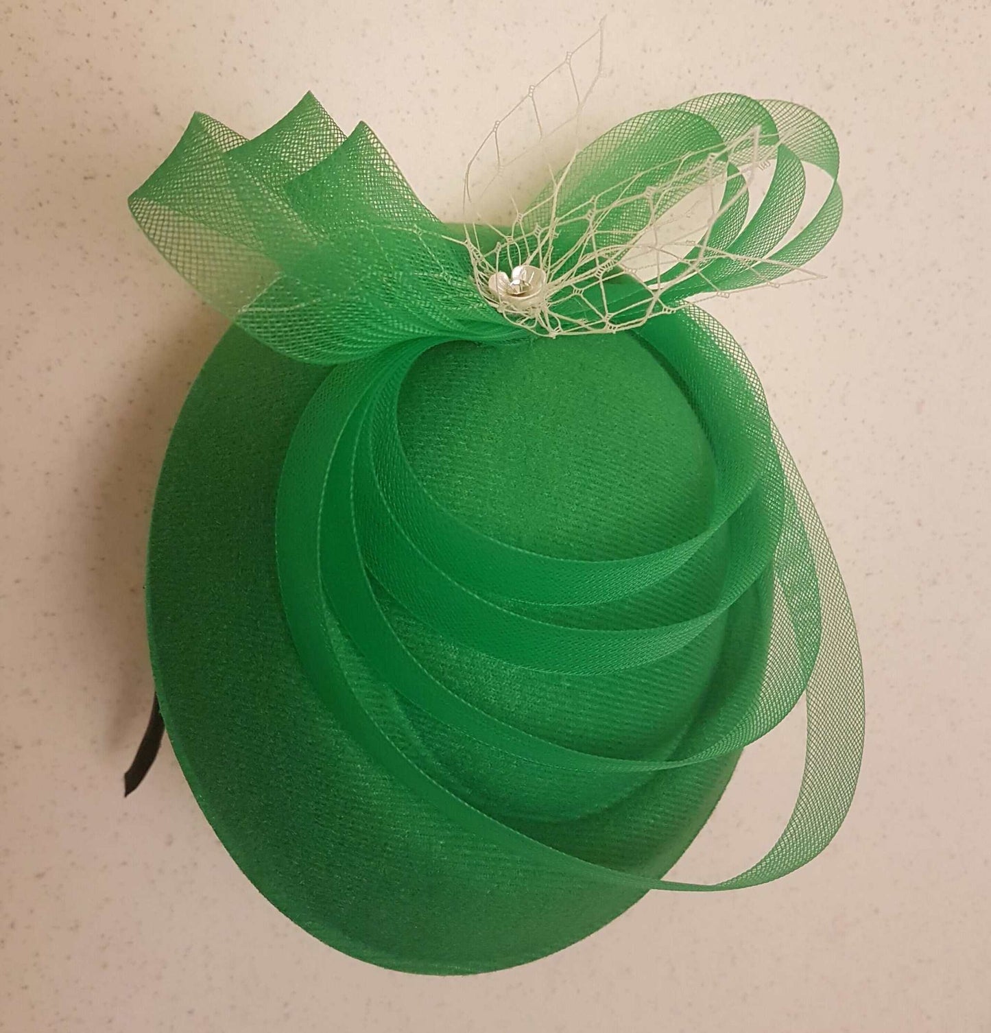 White fascinator hat with mini birdcage veil, vintage-inspired wedding and race headpiece.