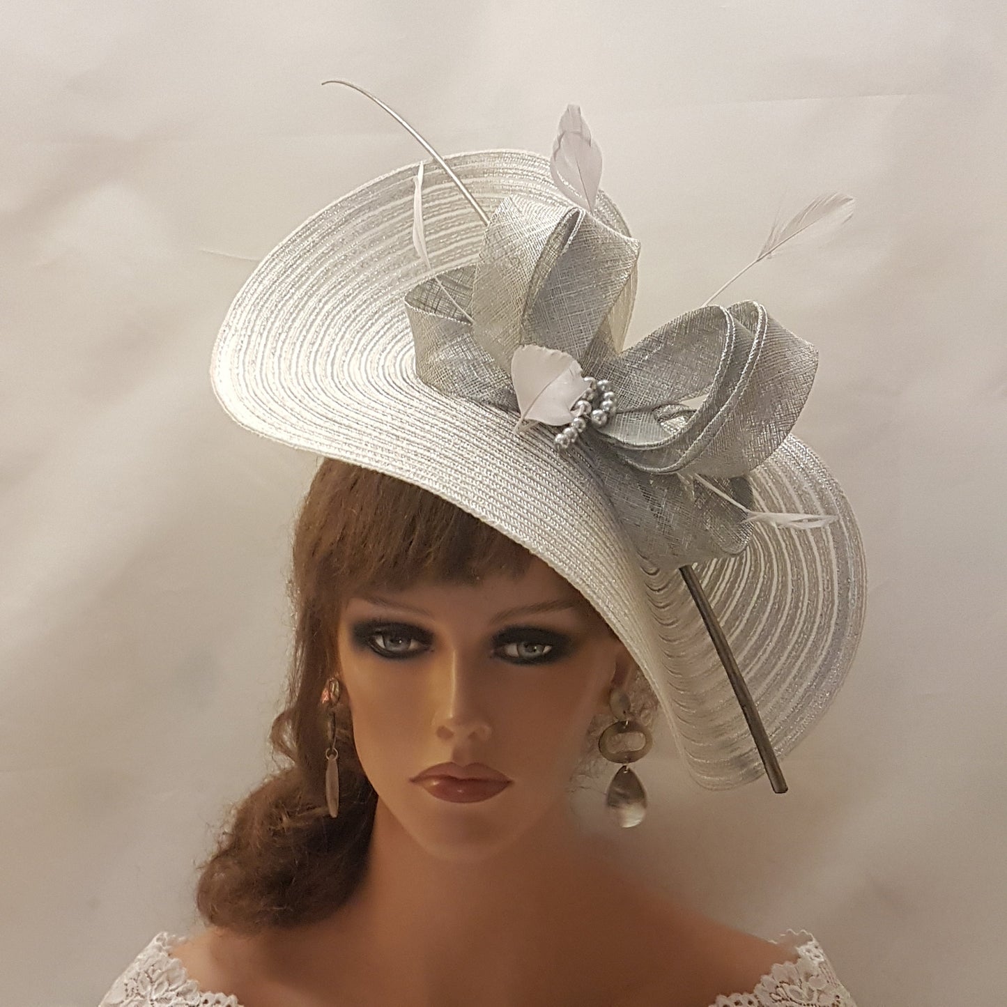 Elegante cappello largo fascinator in argento metallizzato con piume, perle, fiocco. Sofisticato copricapo da sposa, cappello per la madre della sposa, accessorio di tendenza