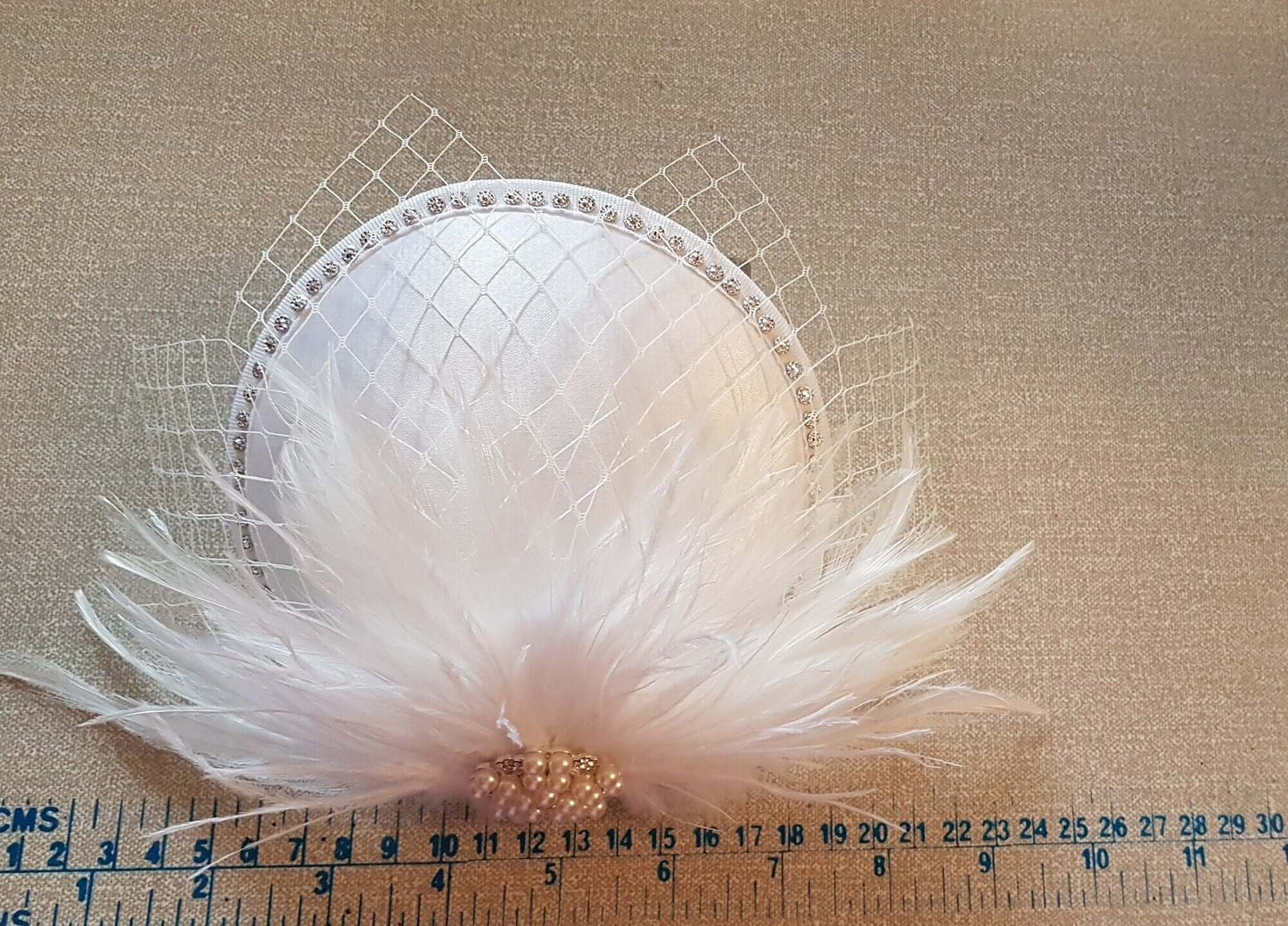 Feather hat fascinator with ivory French netting and pearl crystal jewel.