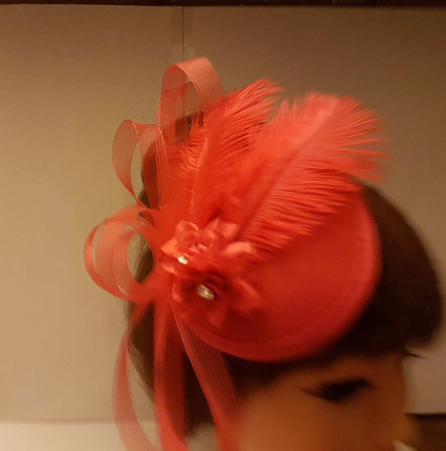 Red ostrich feather hat fascinator with elegant flower and loops for cocktail or wedding events