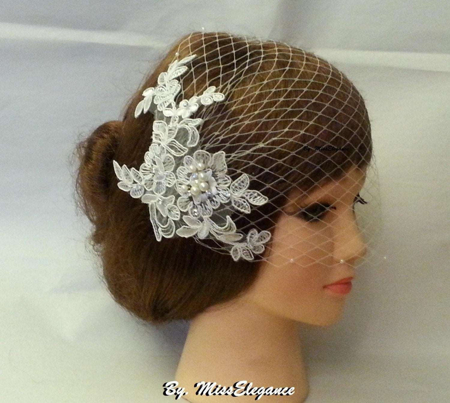 Birdcage veil with white lace fascinator, pearls, and crystals on a mannequin.