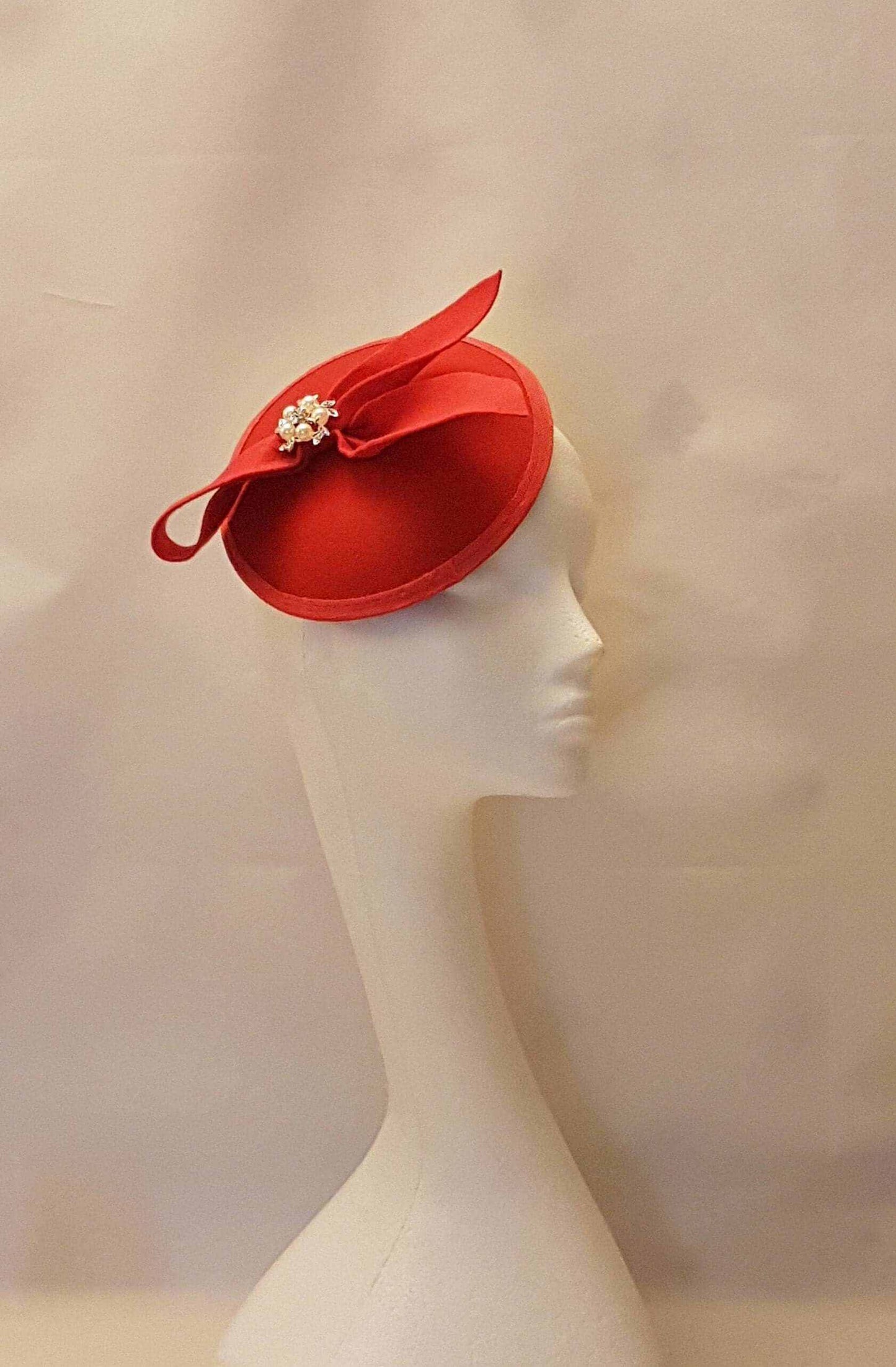 Red fascinator hat with felt bow and crystal pearl center, ideal for weddings, races, and special events.