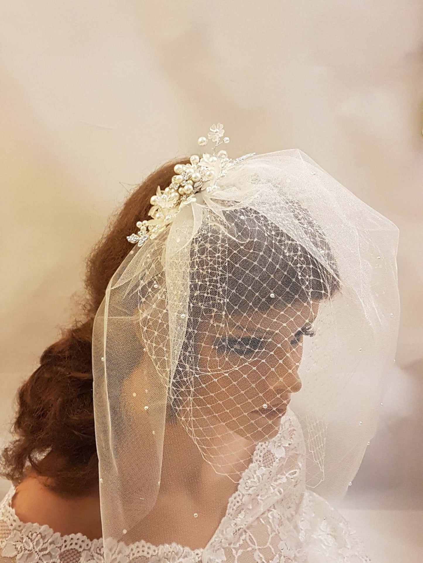 Bridal birdcage veil with lace fascinator and pearl accents, ivory and white wedding hair accessory.