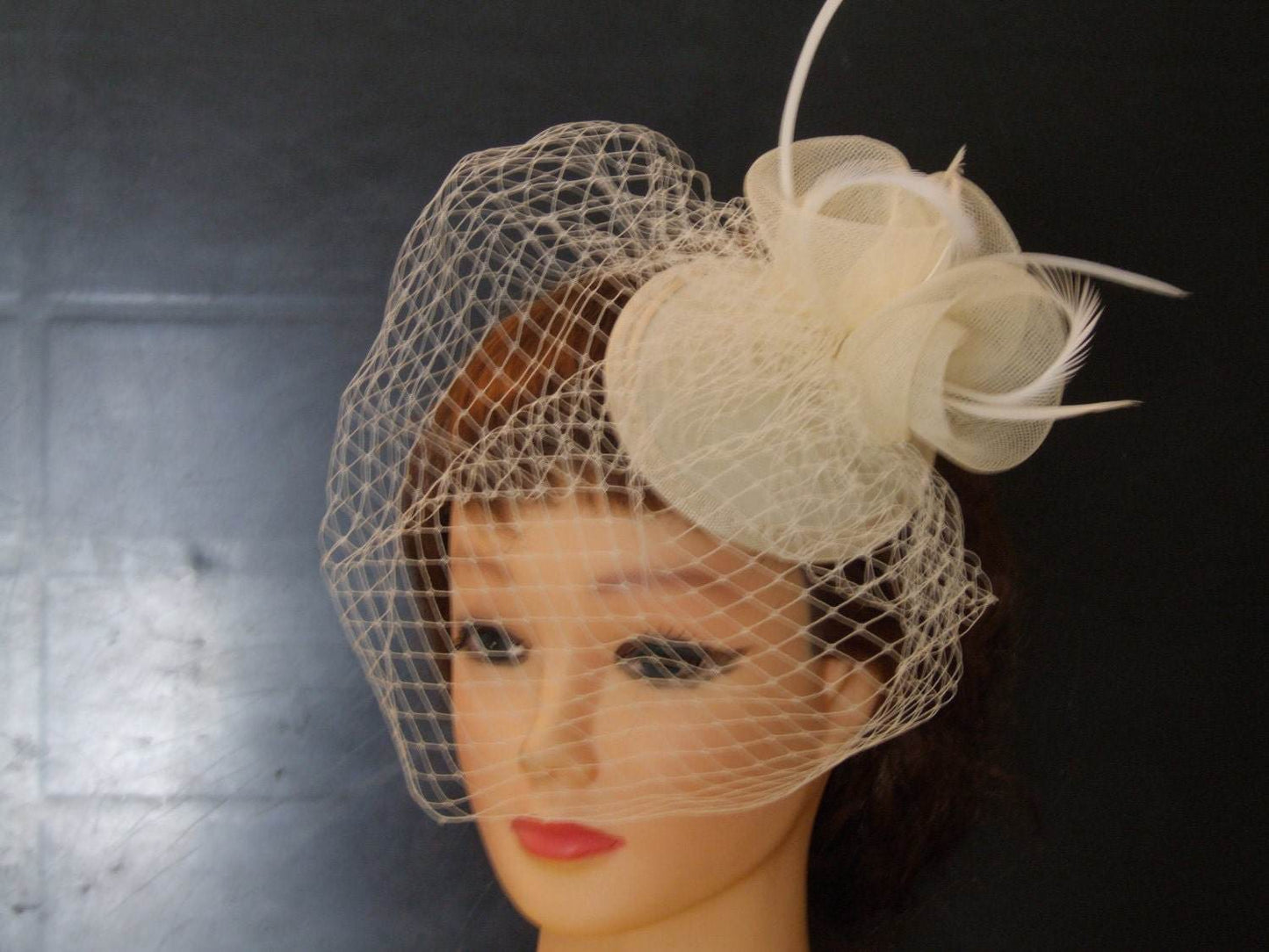 Bridal birdcage veil hat fascinator with ivory flowers and netting, wedding hair accessory.