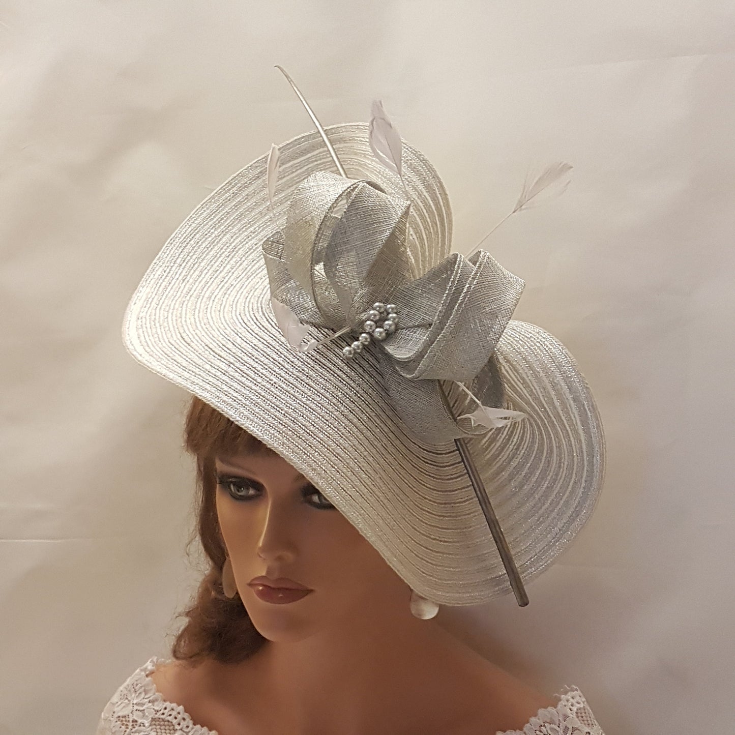 Elegante cappello largo fascinator in argento metallizzato con piume, perle, fiocco. Sofisticato copricapo da sposa, cappello per la madre della sposa, accessorio di tendenza