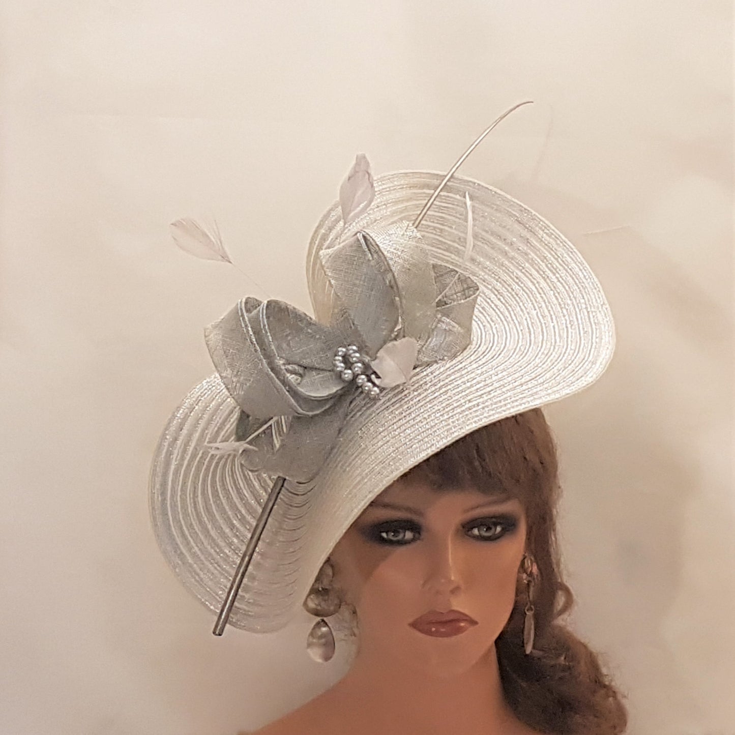 Elegante cappello largo fascinator in argento metallizzato con piume, perle, fiocco. Sofisticato copricapo da sposa, cappello per la madre della sposa, accessorio di tendenza