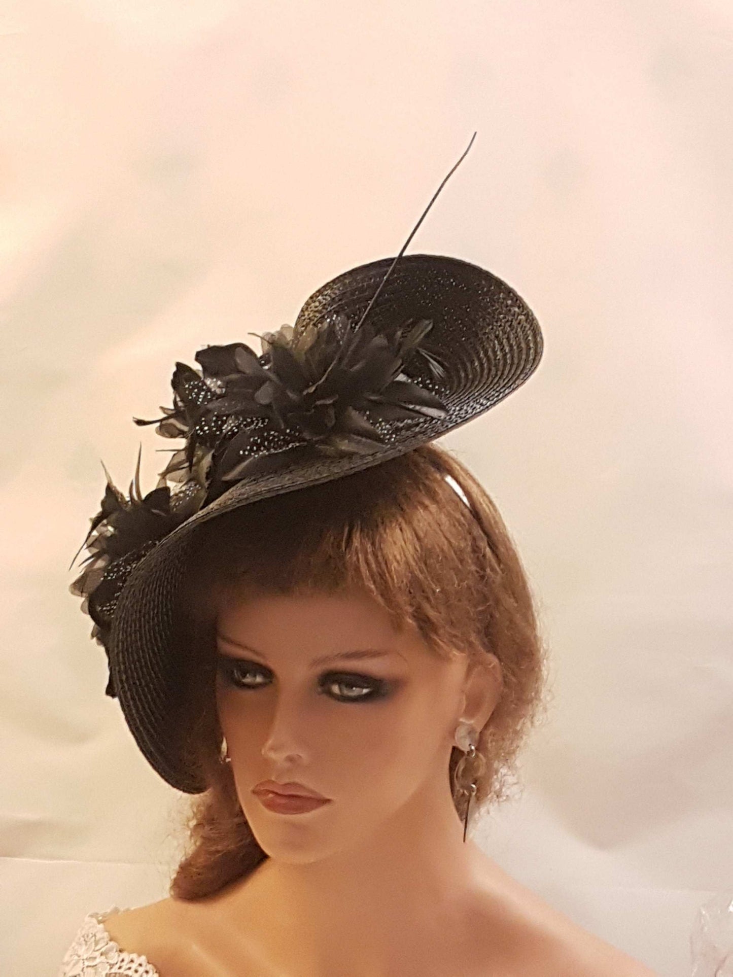 Black large saucer hat fascinator with flowers and feather for weddings and ceremonies.