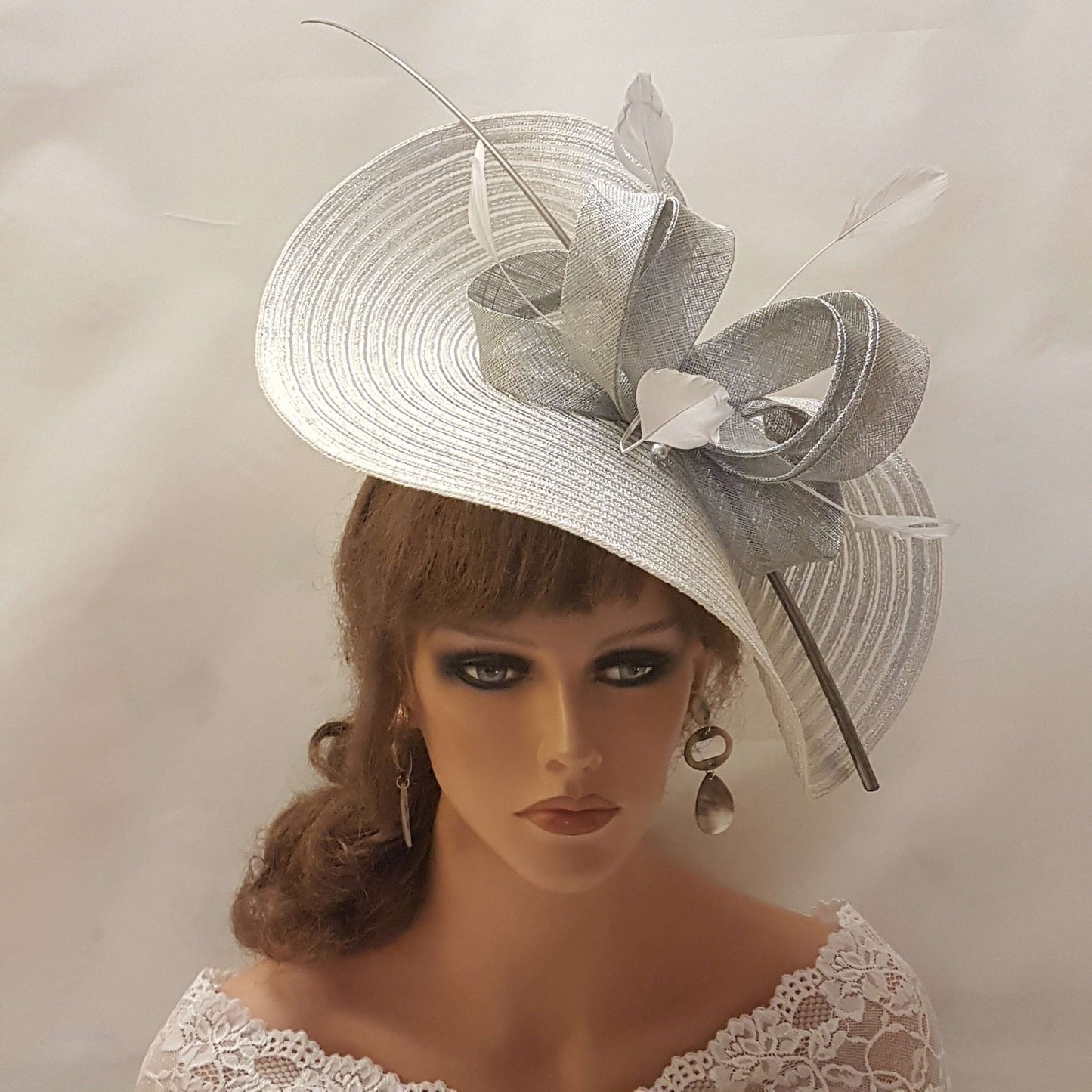 Elegante cappello largo fascinator in argento metallizzato con piume, perle, fiocco. Sofisticato copricapo da sposa, cappello per la madre della sposa, accessorio di tendenza