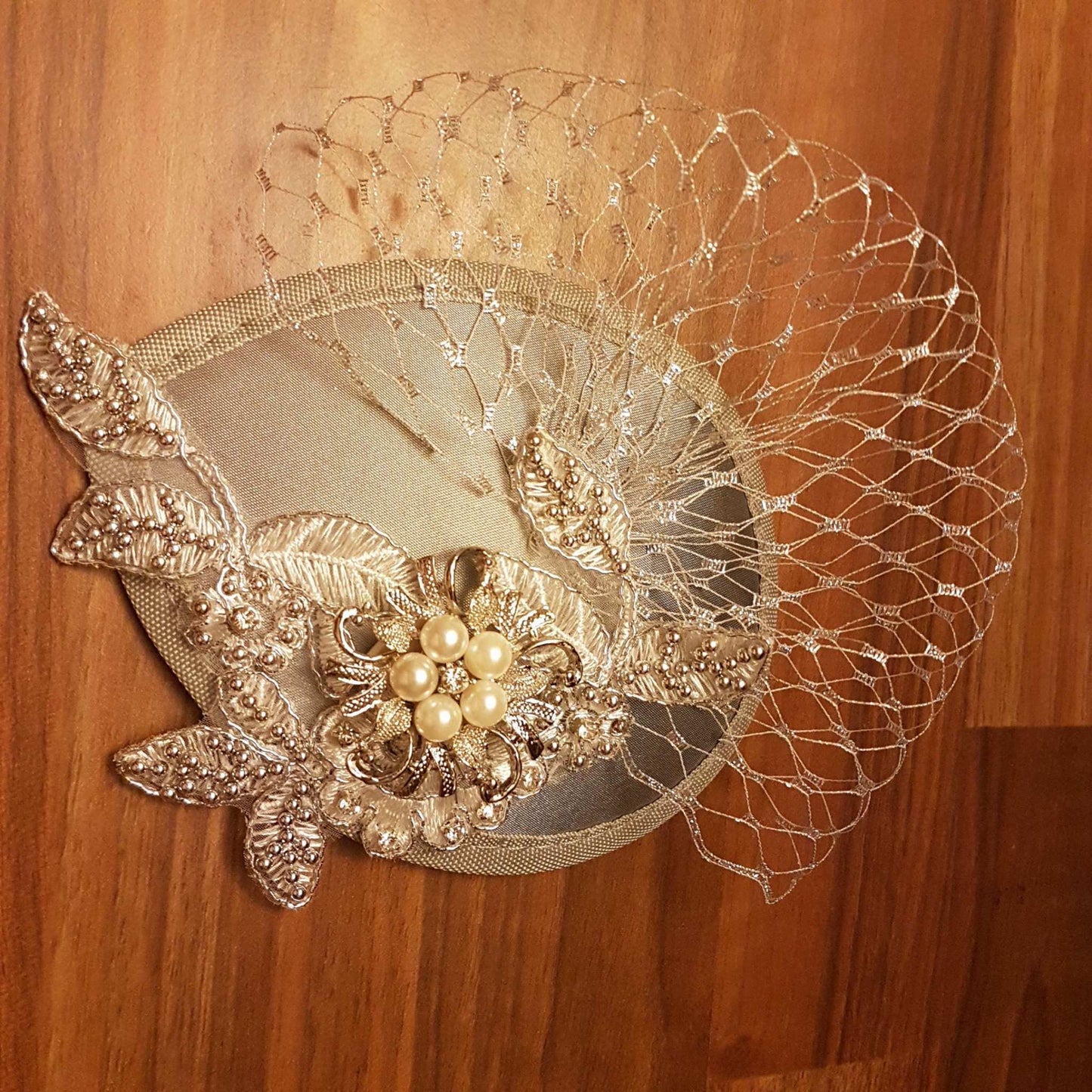 Silver grey bridal hat fascinator with pearl and jewel detail, metallic silver netting, and satin teardrop design