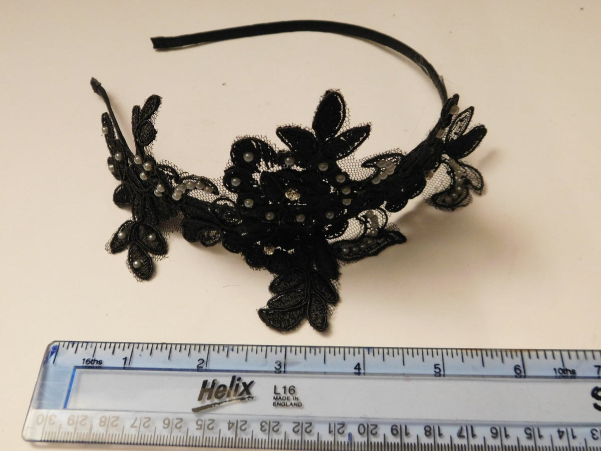 A black lace headband with pearl accents