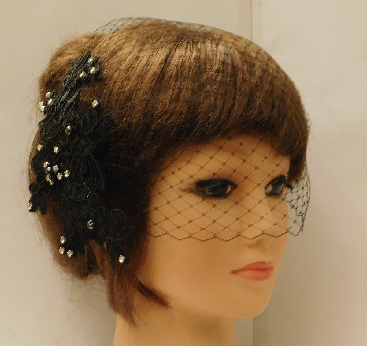 A black lace hairpiece with crystal and pearls  black birdcage veil