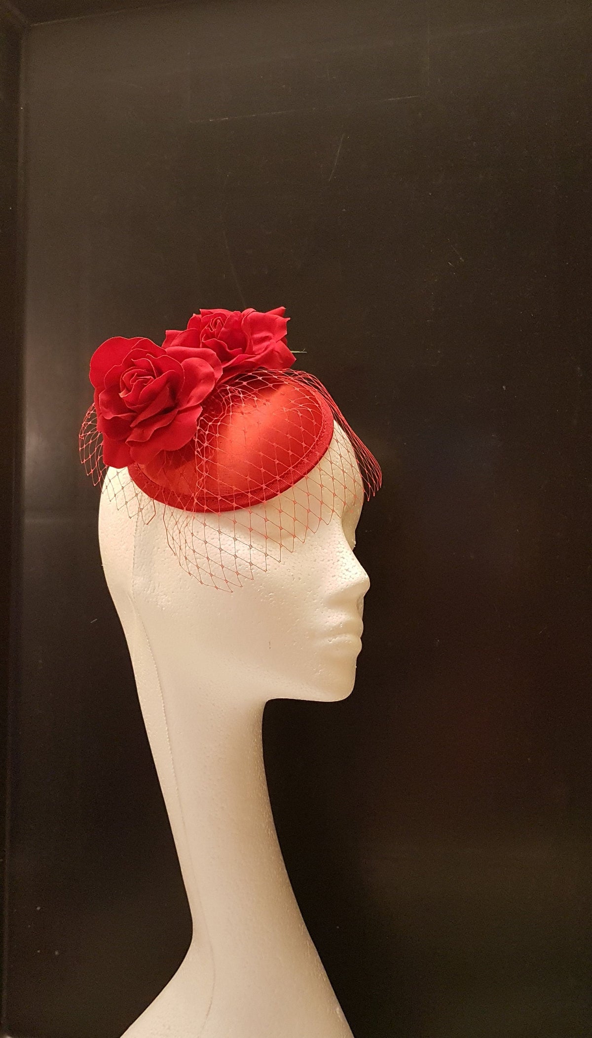 red satin hat with a red rose and a red veil