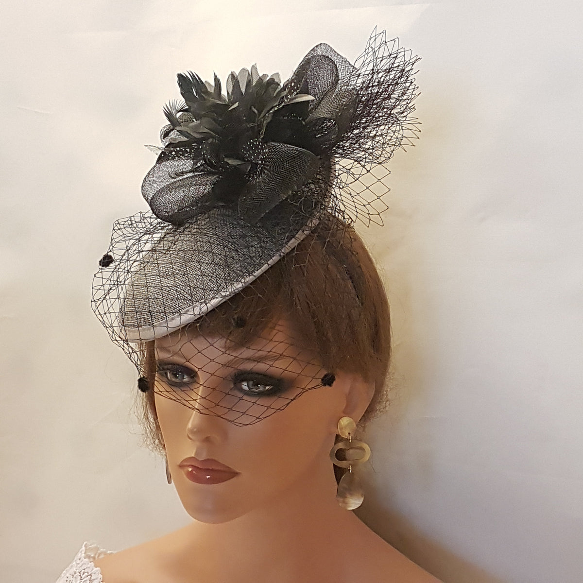 black and Grey fascinator hat with a black feather and netting. for ceremonies Race and theme party