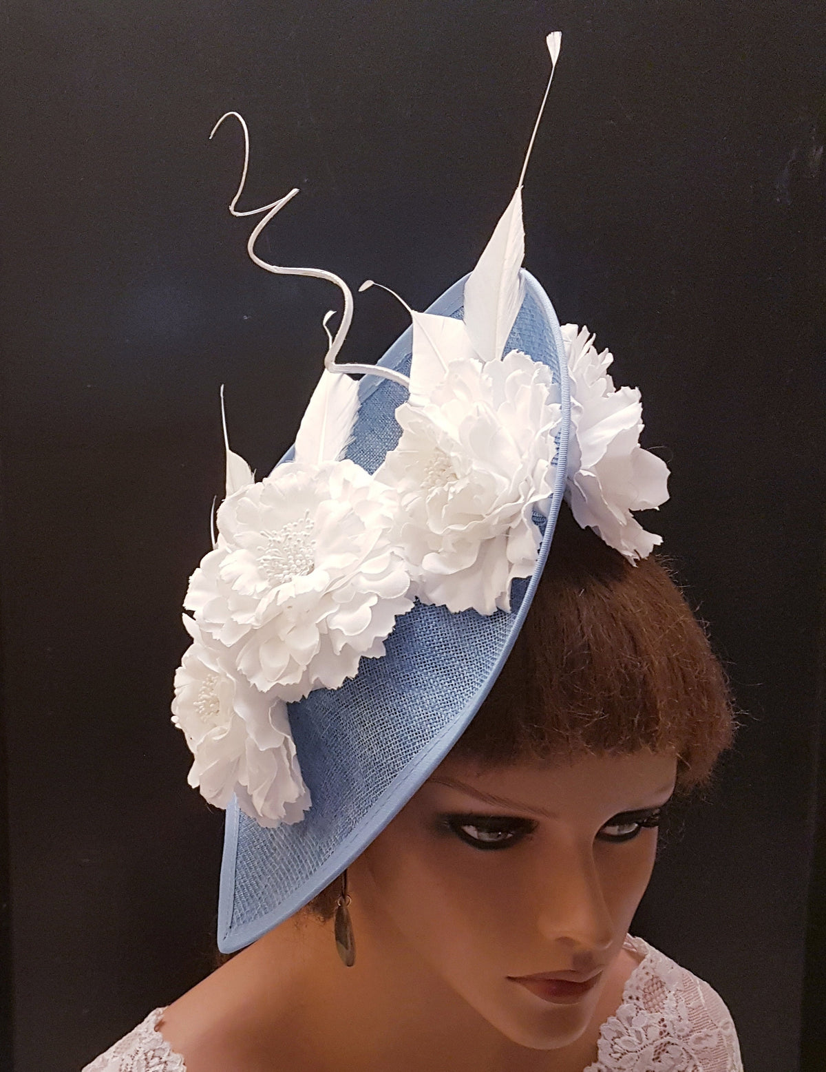 light blue hat with white flower embellishments and a white feather.