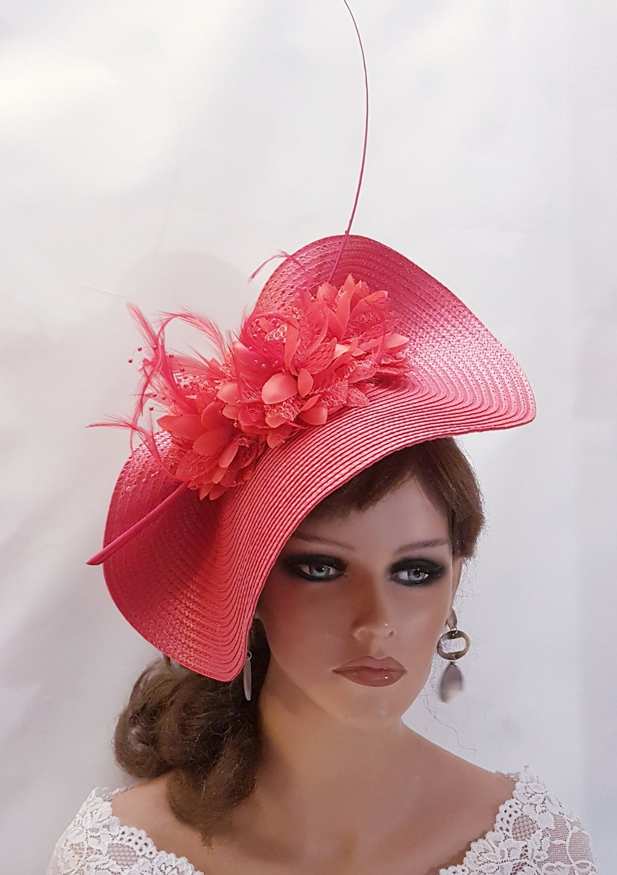 Red hat  with a large flower accent and a feather detail.