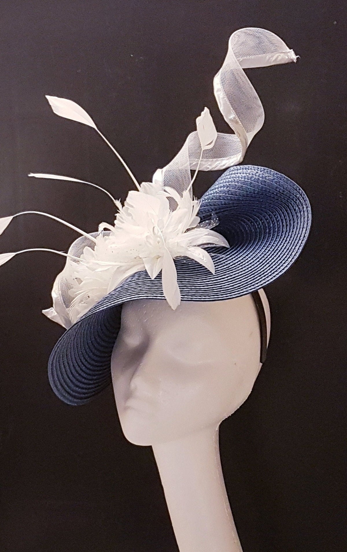 blue and white hat with a white feather and ribbon detail.