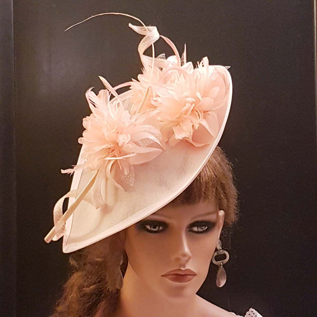 Pink mother of the bride  hat  fascinator A light pink fascinator hat with a large, flat brim and a delicate floral design. The hat is adorned with feathers and a curled ribbon.