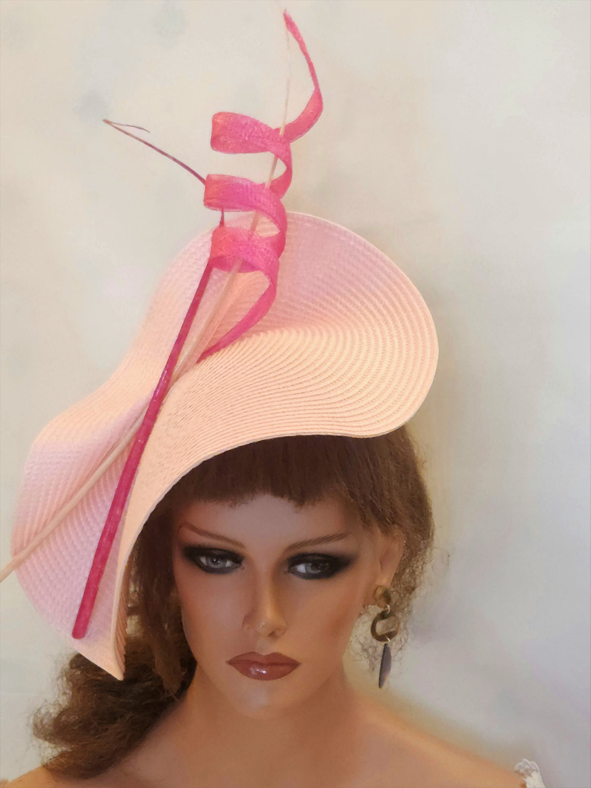 pink straw hat with a pink ribbon and feather detail.