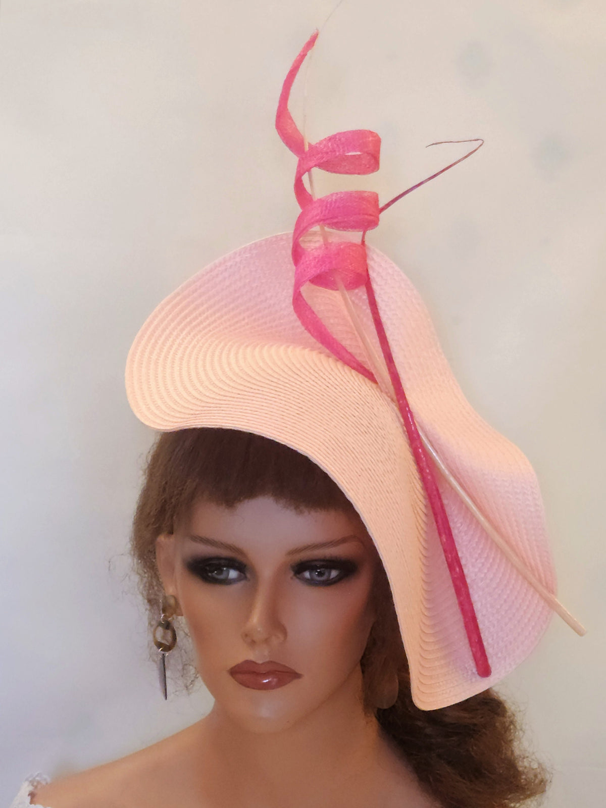 pink and white hat with a pink ribbon and feather detail.