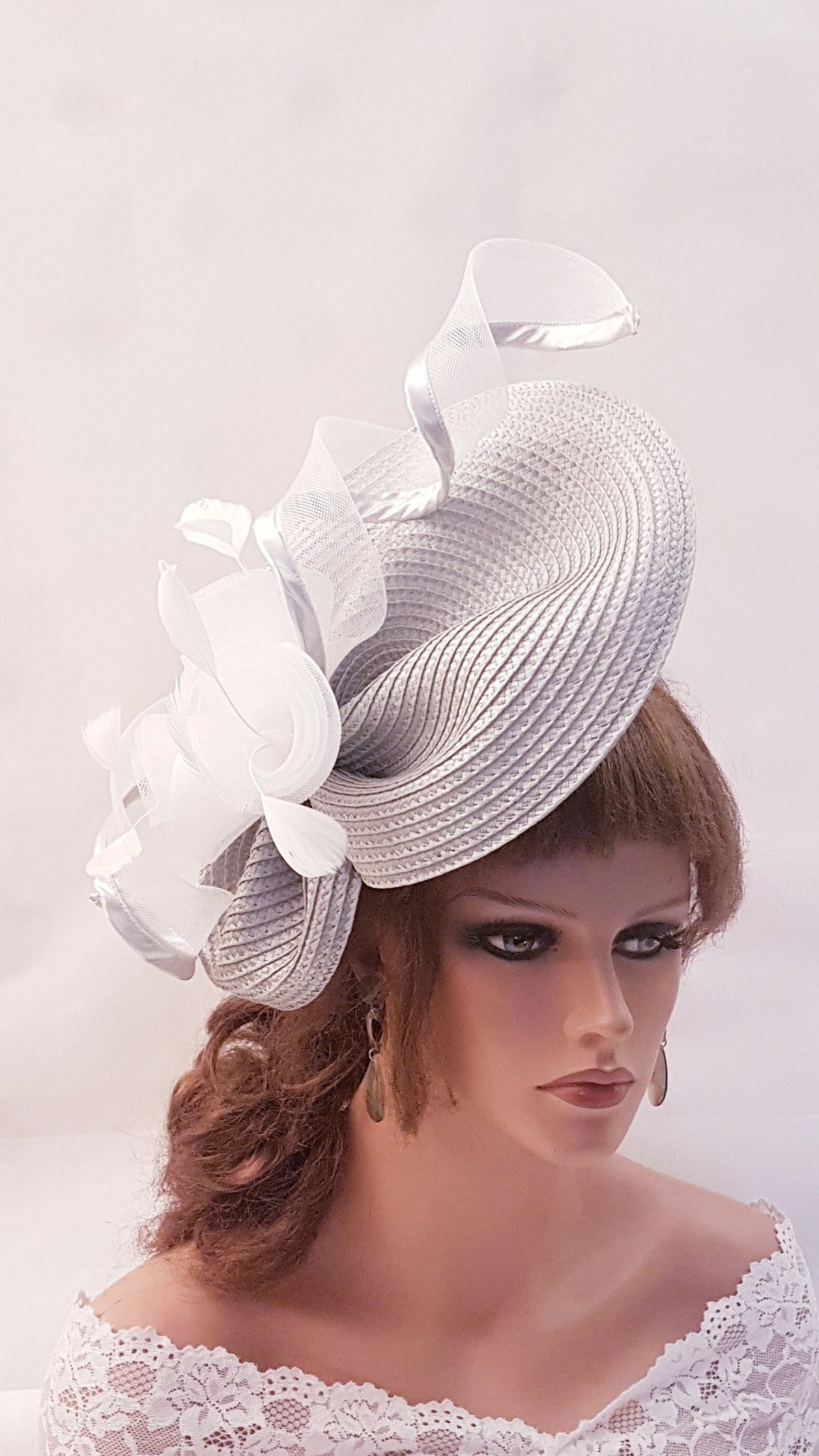 Silver grey straw hat with a white satin ribbon and a white feather flower accent.