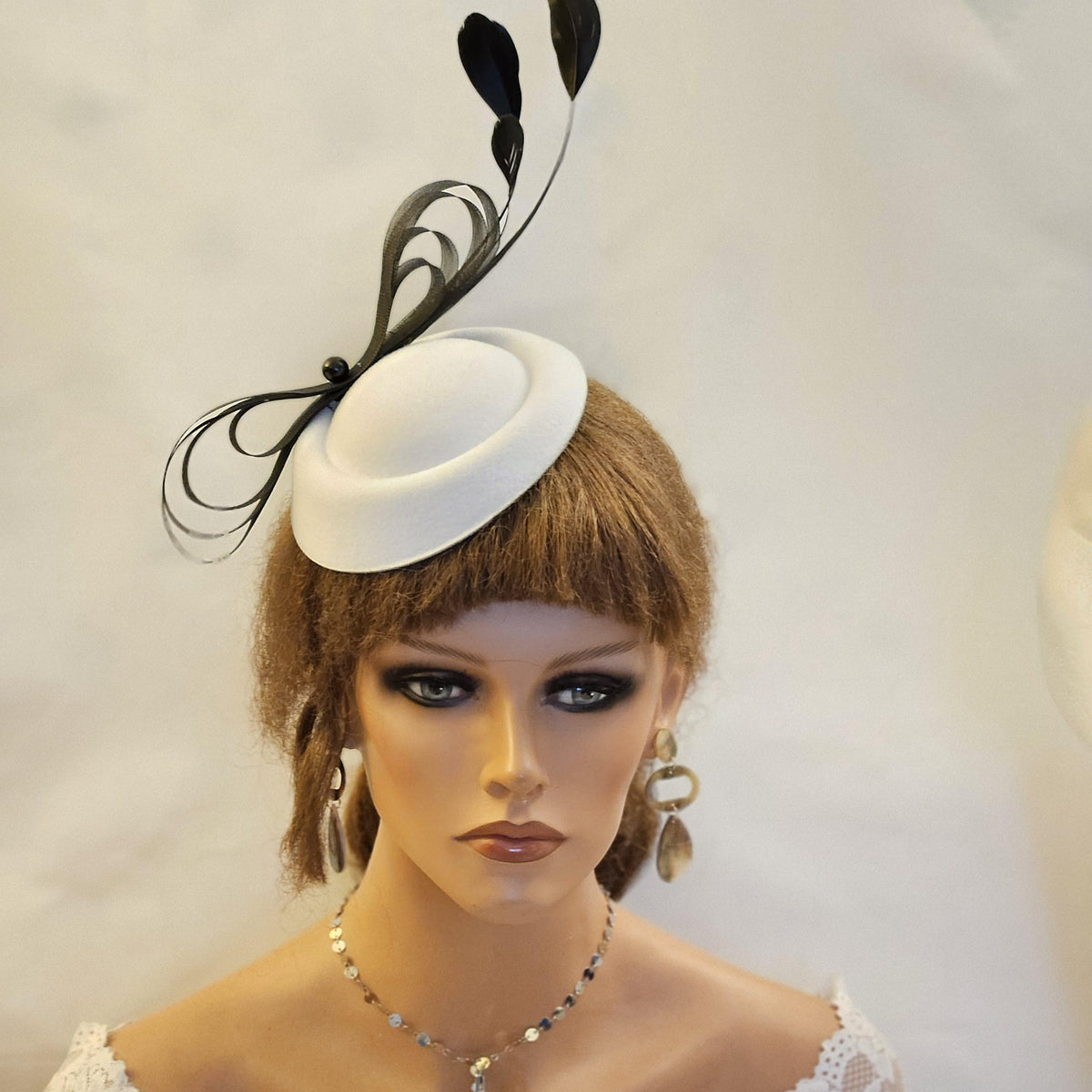 White fascinator with black feathers and crinoline loops
