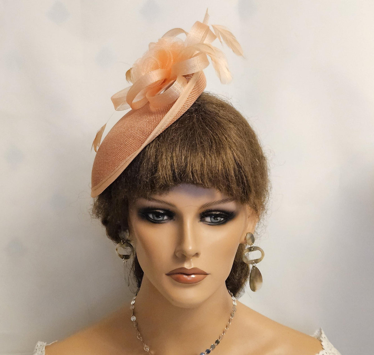 Peach fascinator with feathers and crinoline roses and bows
