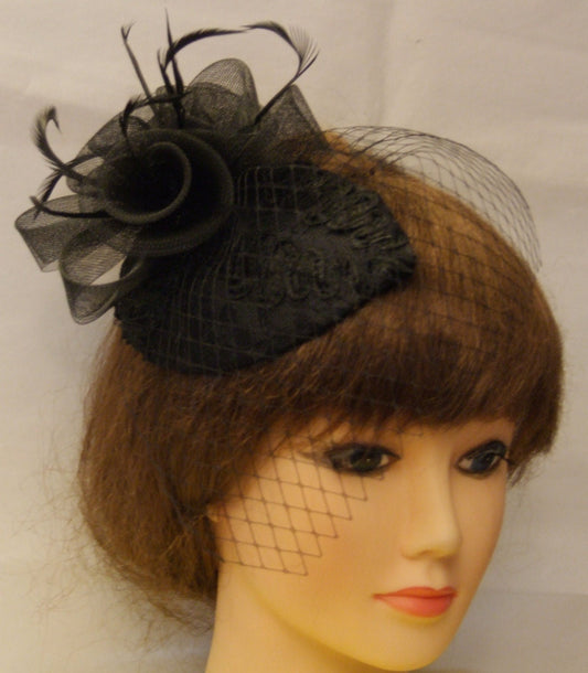 black fascinator with a mini black veil and a black feather accent.