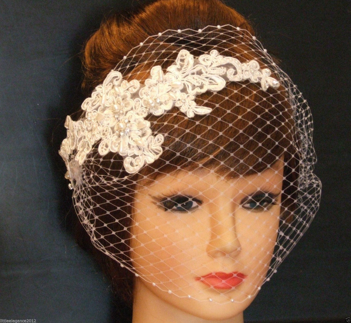 bridal birdcage veil with a delicate lace trim and pearl embellishments.