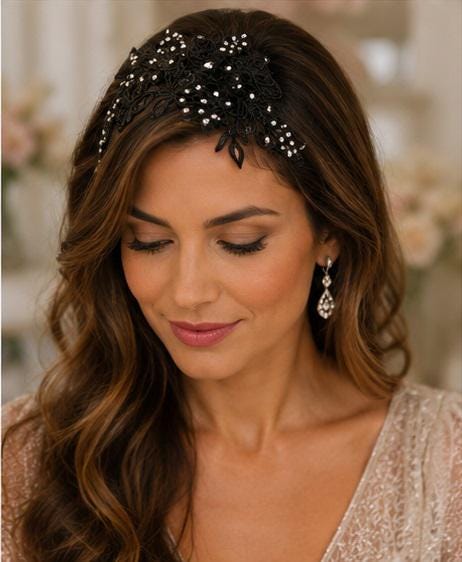 A black lace headband featuring intricate floral patterns and scattered clear crystals.